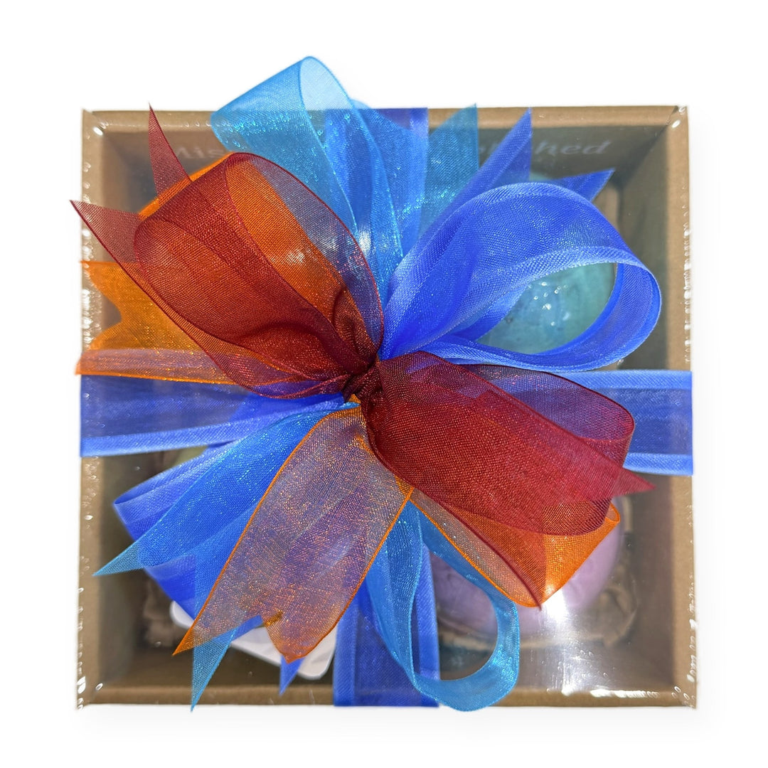 Bath bomb gift box tied with a blue, red and orange organza ribbon bow, top view