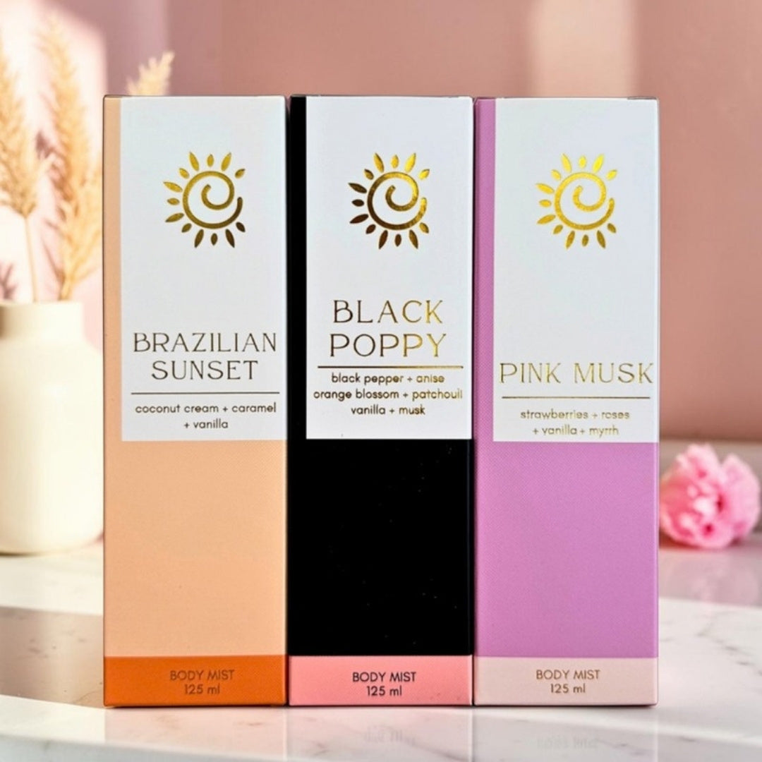 Brazilian Sunset, Black Poppy and Pink Musk body mist gift boxes in a sunny pink bathroom with pampas grass and a peony