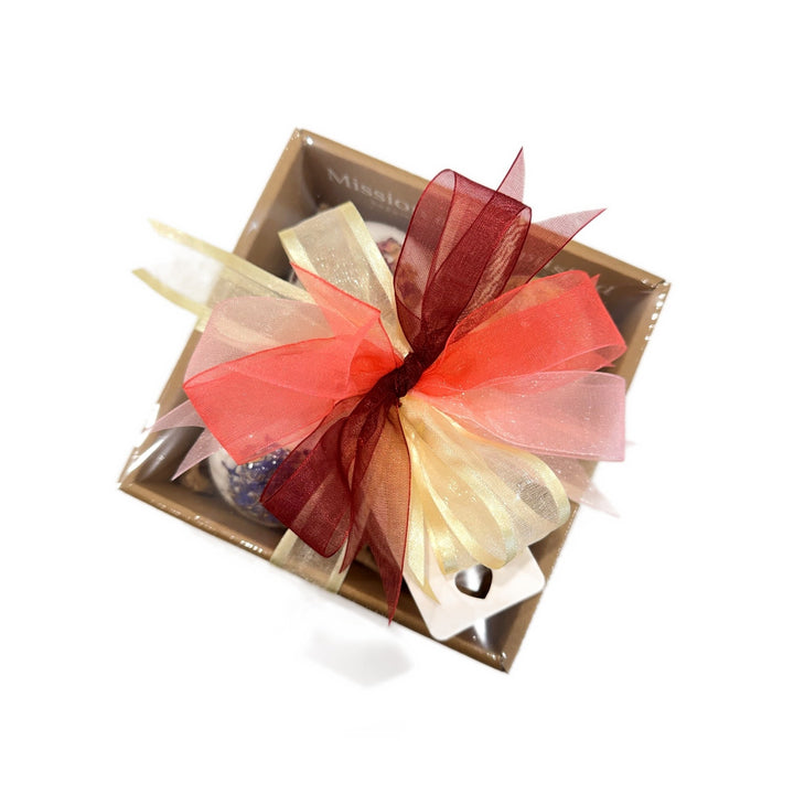 Botanical Bath Bomb Gift Box with red ribbon bow, viewed from above