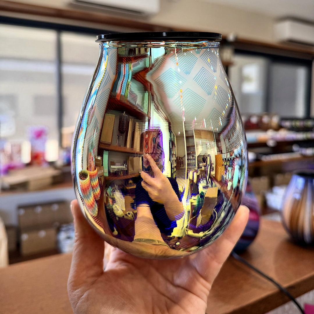 Seraphina glass wax warmer held in hand showing the reflective mirror finish