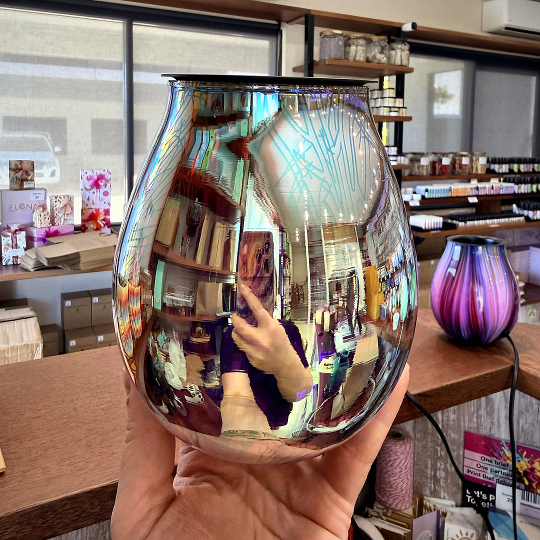 Twilight glass wax warmer held in hand showing the reflective mirror finish